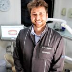 un homme souriant à la caméra